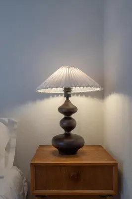 a lamp on a wooden table next to a bed at Astrid in Athens