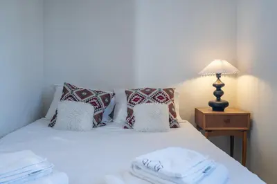 a bedroom with a white bed with pillows and a lamp at Astrid in Athens
