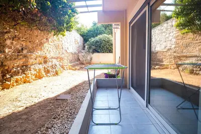 a table sitting on a porch next to a building at Luxury suites XiangBaLa Glyfada in Athens