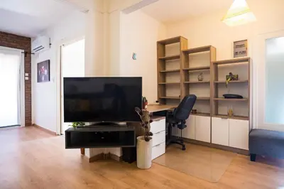 a living room with a television and a chair at Luxury suites XiangBaLa Glyfada in Athens