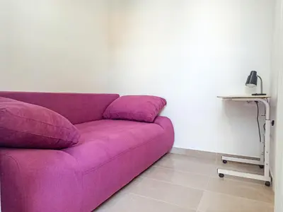 a purple couch in a room with a table at Kremou Studio in Athens