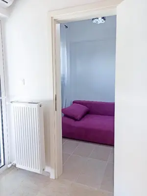 a living room with a purple couch in a room at Kremou Studio in Athens