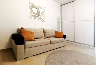 a living room with a couch and a mirror at Kremou Studio in Athens