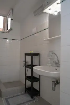 a white bathroom with a sink and a mirror at Casanova94 Guesthouse in Piraeus