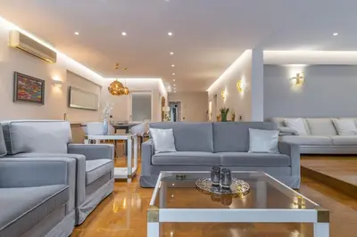 a living room with blue couches and a table at The HostMaster Luminous Elite Estate in Athens