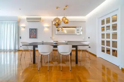 a dining room with a black table and white chairs at The HostMaster Luminous Elite Estate in Athens
