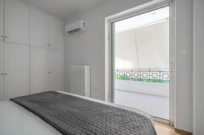 a bedroom with a bed and a large window at Varkiza Sea Front Residence by First Class Properties in Vari