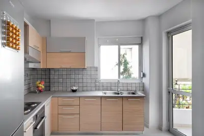 a kitchen with wooden cabinets and a sink and a window at Varkiza Sea Front Residence by First Class Properties in Vari