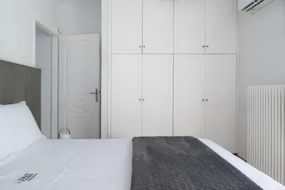 a bedroom with a large bed with white cabinets at Varkiza Sea Front Residence by First Class Properties in Vari