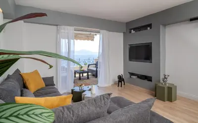 a living room with a couch and a tv at Varkiza Sea Front Residence by First Class Properties in Vari