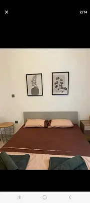 a large bed in a room with two pictures on the wall at ANAFIS STUDIO in Athens