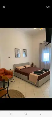 a bedroom with a large bed and a chair at ANAFIS STUDIO in Athens