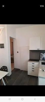 a kitchen with white cabinets and a black counter top at ANAFIS STUDIO in Athens