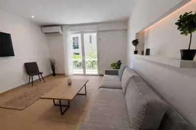 a living room with a large couch and a table at Modern flat close to the beach-ground floor in Athens
