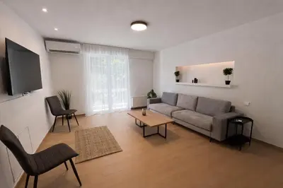 a living room with a couch and a table at Modern flat close to the beach-ground floor in Athens