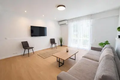 a living room with a couch and a table at Modern flat close to the beach-ground floor in Athens