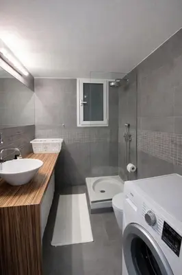a bathroom with a sink and a washing machine in it at Modern flat close to the beach-ground floor in Athens