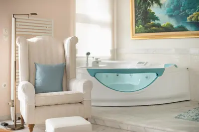 a bathroom with a bath tub and a chair at Varkiza Riviera in Varkiza