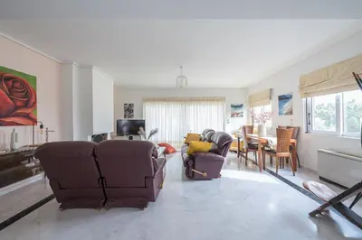 a living room with couches and a dining room at Varkiza Riviera in Varkiza