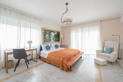 a bedroom with a bed and a desk and a chair at Varkiza Riviera in Varkiza