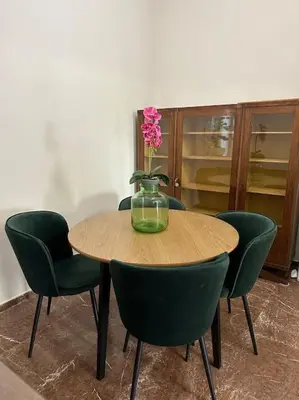 a table with green chairs and a vase with a flower on it at LP appartment athens in Psikhikón