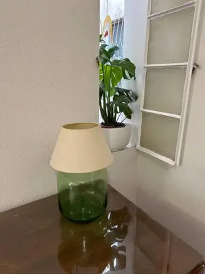 a glass vase sitting on a table with a lamp at LP appartment athens in Psikhikón