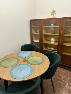 a table with four green chairs and a cabinet at LP appartment athens in Psikhikón