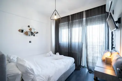 a bedroom with a white bed and a window at Duplex Penthouse with Sauna & Acropolis View in Athens