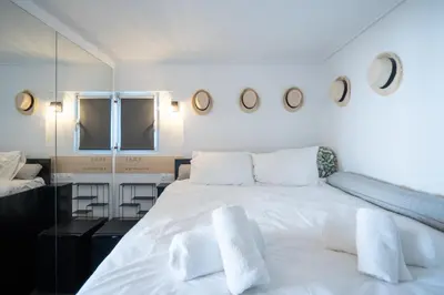 a bedroom with a large white bed with white pillows at Duplex Penthouse with Sauna & Acropolis View in Athens