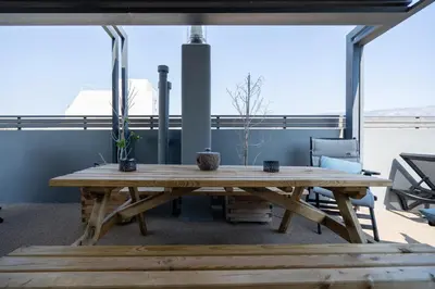 a large wooden table in a room with windows at Duplex Penthouse with Sauna & Acropolis View in Athens