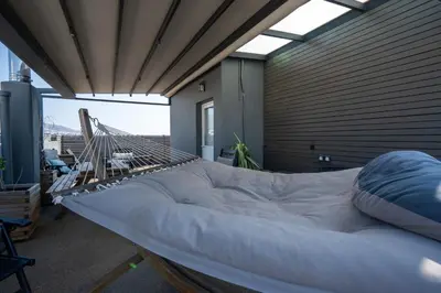 a large bed in a room with a balcony at Duplex Penthouse with Sauna & Acropolis View in Athens