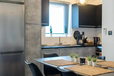 a kitchen with two tables and a refrigerator at Duplex Penthouse with Sauna & Acropolis View in Athens