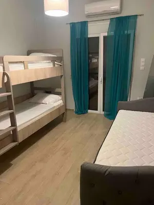 a room with two bunk beds with blue curtains at Cozy 2BD Beachfront Escape In The Heart Of Glyfada in Athens