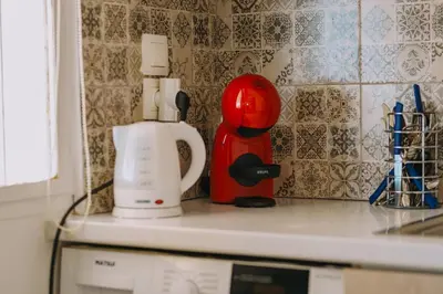 a kitchen counter with a mixer and a coffee maker at Top-Floor Studio in Glyfada Center with Sea View in Athens