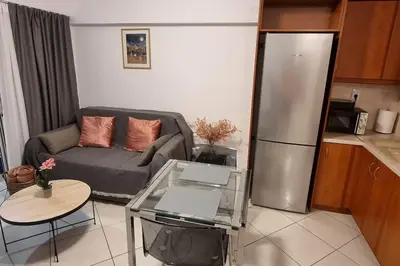a living room with a couch and a refrigerator at Park View - PS4 in Piraeus