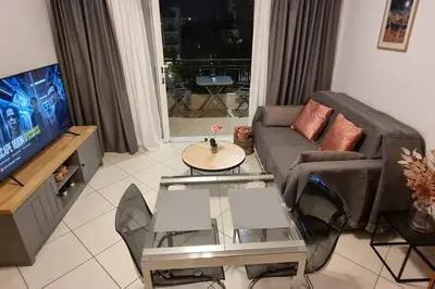 a living room with a couch and a table and a tv at Park View - PS4 in Piraeus
