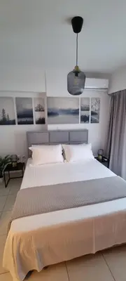 a bedroom with a large white bed with a pendant at Park View - PS4 in Piraeus