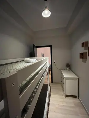 a bedroom with a white bed and a white dresser at Katerina Holiday House in Anavissos