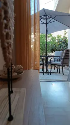 a view of a balcony with an umbrella and a table at Katerina Holiday House in Anavissos