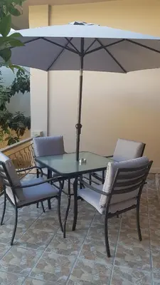a table and chairs with an umbrella on a patio at Katerina Holiday House in Anavissos