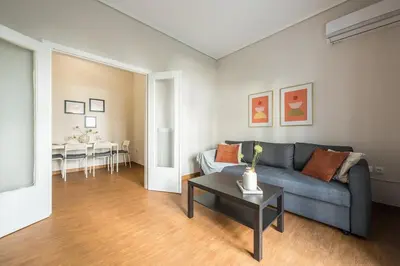 a living room with a blue couch and a table at Comfortable Apartment In Athens in Athens