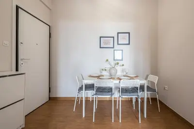 a white dining room with a table and chairs at Comfortable Apartment In Athens in Athens