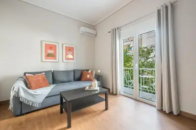 a living room with a blue couch and a table at Comfortable Apartment In Athens in Athens