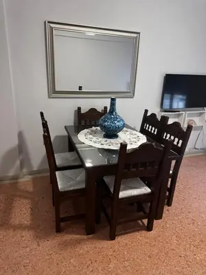 a table with chairs and a vase on top of it at Sea view apartment steps away from the Beach Anavyssos Palaia Fokaia in Áyios Yeóryios