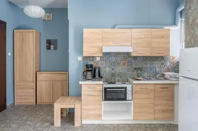 a kitchen with wooden cabinets and a stove top oven at Private Voula Beach Suite in Athens