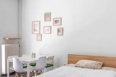 a bedroom with a bed and a table and chairs at Private Voula Beach Suite in Athens