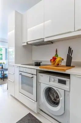 a white kitchen with a washing machine in it at Hidden Gem: 2BR Artistic Retreat in Glyfada Center in Athens