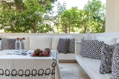 a white couch with pillows and a plate of fruit on it at Hidden Gem: 2BR Artistic Retreat in Glyfada Center in Athens