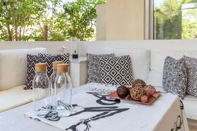 a white couch with a table with glasses and balls on it at Hidden Gem: 2BR Artistic Retreat in Glyfada Center in Athens