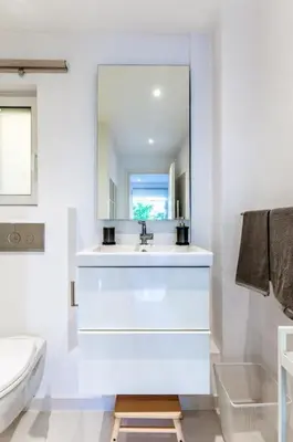 a white bathroom with a sink and a mirror at Hidden Gem: 2BR Artistic Retreat in Glyfada Center in Athens